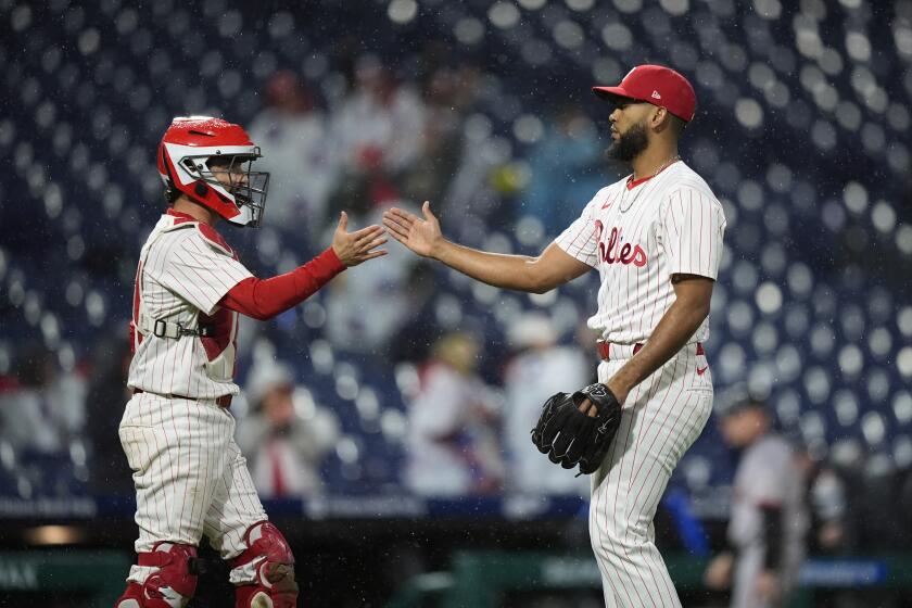 Garrett Stubbs, de los Filis de Filadelfia, a la izquierda, y Seranthony Domínguez celebran después de que los Filis ganaron un partido de béisbol contra los Gigantes de San Francisco, el sábado 4 de mayo de 2024, en Filadelfia. (AP Foto/Matt Slocum)