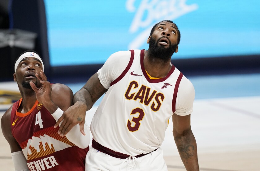 Denver Nuggets forward Paul Millsap, left, fights for position for a rebound with Cleveland Cavaliers center Andre Drummond in the second half of an NBA basketball game Wednesday, Feb. 10, 2021, in Denver. (AP Photo/David Zalubowski)