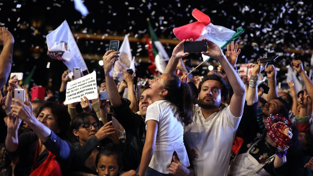 Supporters of Andres Manuel Lopez Obrador cheer as he makes an appearance in Mexico City's Zocalo on July 1, 2018.