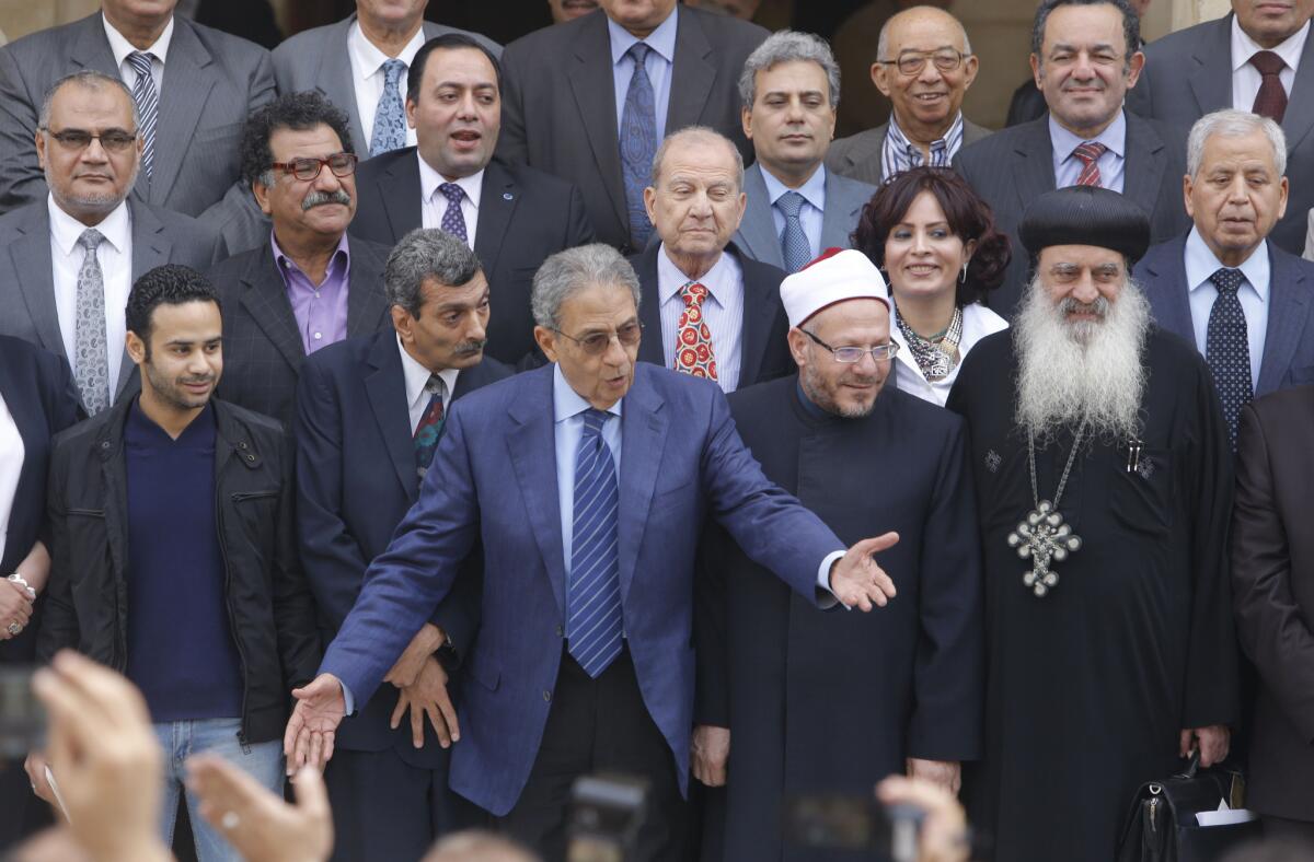 Amr Moussa, center, the chairman of Egypt's 50-member panel responsible for amending the country's Islamist-drafted constitution, arranges the members for a group picture in Cairo after finishing the final draft of a series of constitutional amendments.
