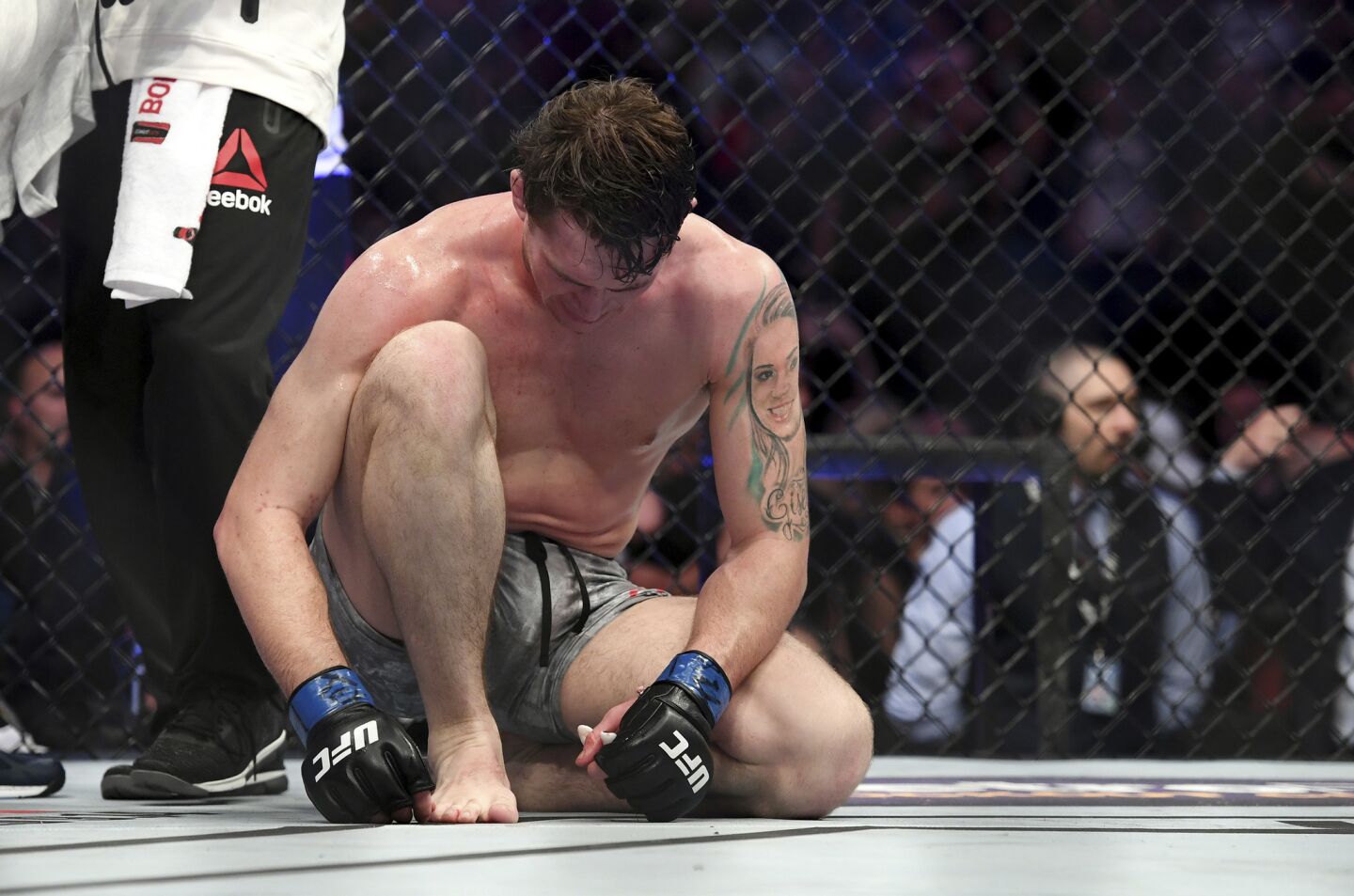 Darren Till sits on the mat after losing by submission to Tyron Woodley in their welterweight title mixed martial arts bout at UFC 228 on Saturday, Sept. 8, 2018, in Dallas. (AP Photo/Jeffrey McWhorter)