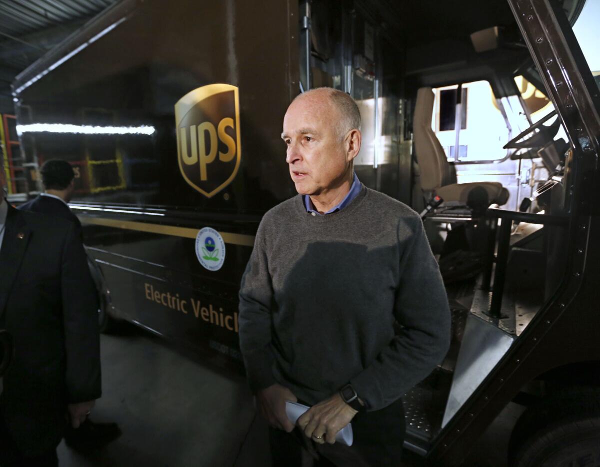 Gov. Jerry Brown talks to reporters after inspecting an electric-powered UPS delivery truck at the UPS distribution center in West Sacramento last month.