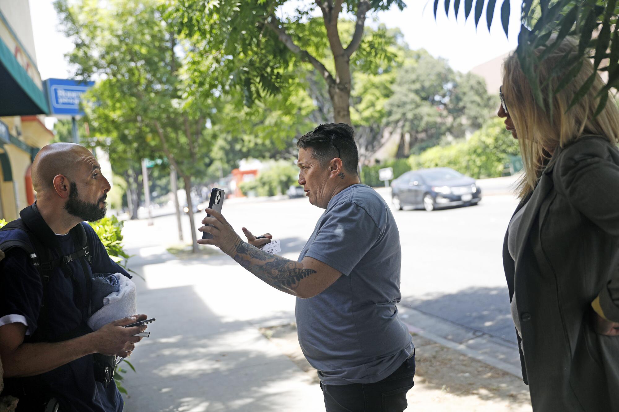 A man shows a photo of Sherry Hill's daughter to another man, standing outside of a motel.