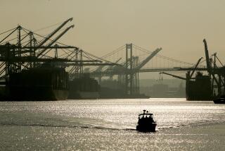 LOS ANGELES, CALIF. - DEC. 2, 2021. A pleasure boat motors past ships unloading cargo containers in the Port of Los Angeles on Wednesday, Dec. 1, 2021. Port workers are trying to clear a supply chain backlog ahead of the yearend holidays. The activity has resulted in spikes of carbon emmissions in the surrounding communities of San Pedro, Wilmington and Long Beach. (Luis Sinco / Los Angeles Times)