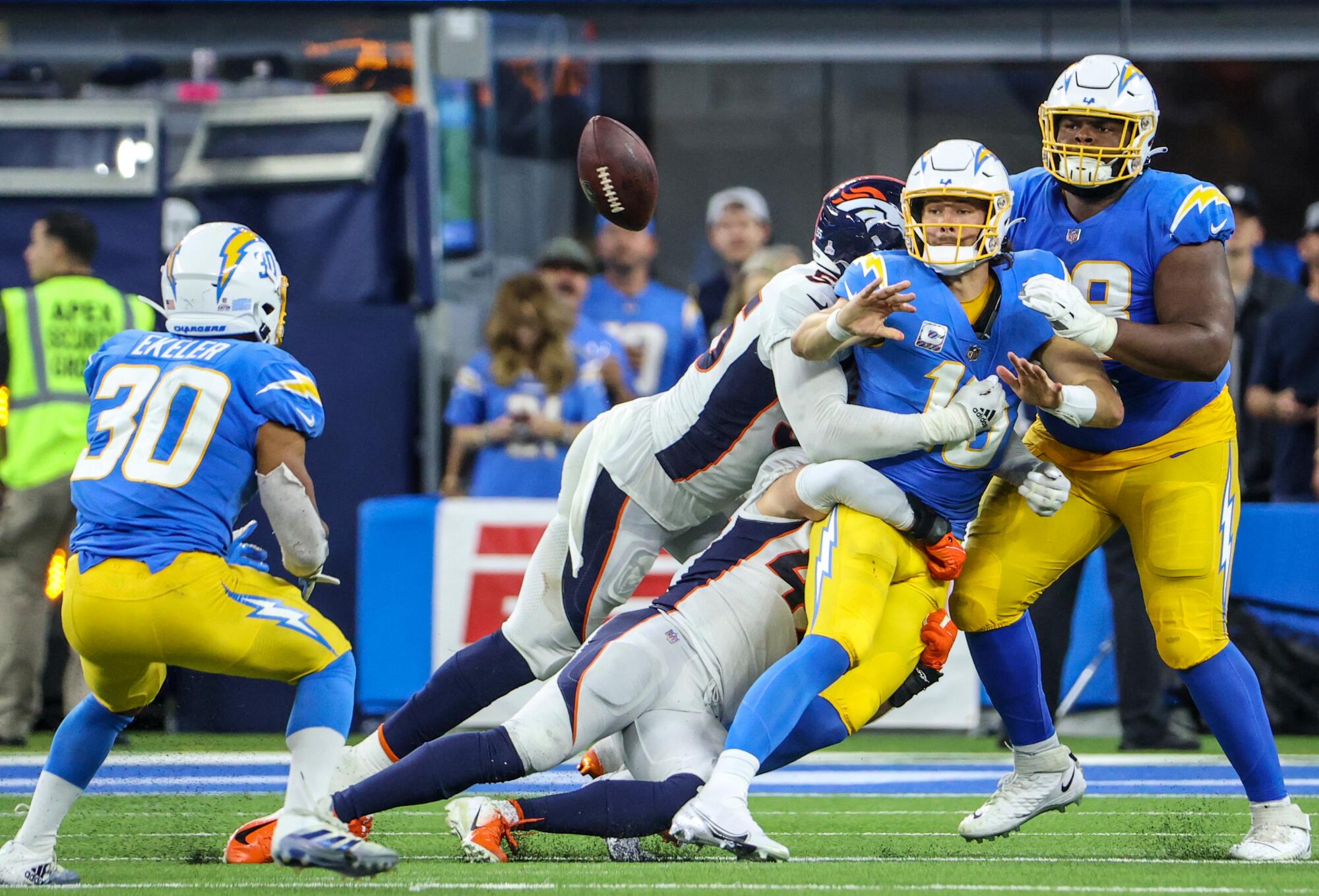 Chargers quarterback Justin Herbert flips a pass to running back Austin Ekeler just before being sacked.