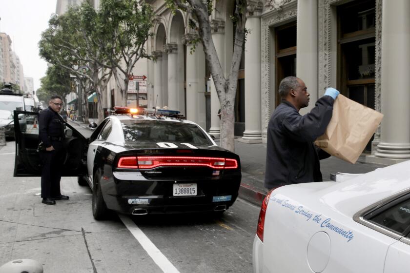 LOS ANGELES CA THURSDAY MAY 5, 2022 - A crime scene investigator leaves the scene where three men were found dead in an apartment building at 650 South Spring Street in downtown Los Angeles from a fentanyl overdose Thursday morning, May 5, 2022. (Irfan Khan / Los Angeles Times)