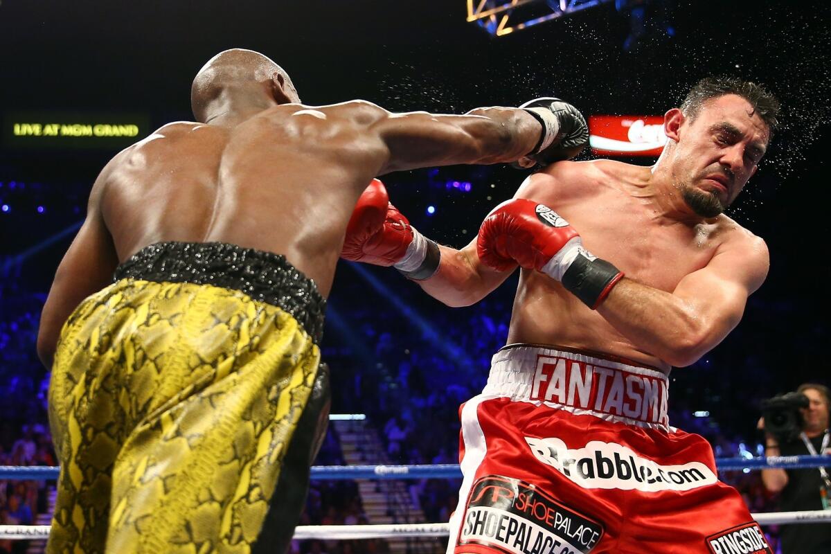 Floyd Mayweather Jr. sends Robert Guerrero reeling with an overhand right to the head in their WBC welterweight title fight on Saturday night at the MGM Grand Garden Arena.