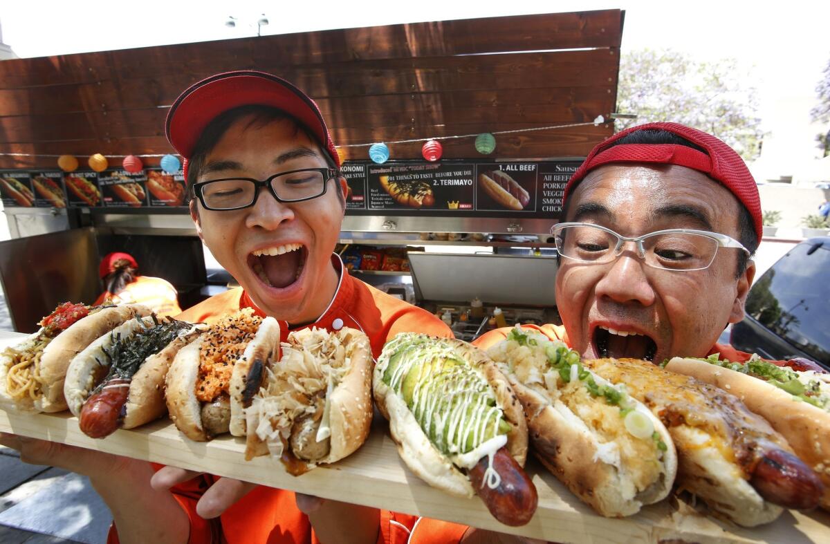 Hideki Aizawa, left, marketing manager, and Noriki Tamura, owner of Japadog, display the different hot dogs they make.