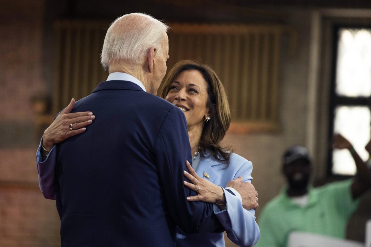 Vice President Kamala Harris faces forward while embracing President Biden