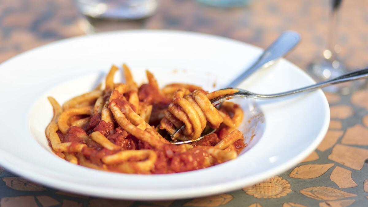 A plate of pici all'aglione, a hand-rolled pasta with a garlic tomato sauce at Bulgarini.