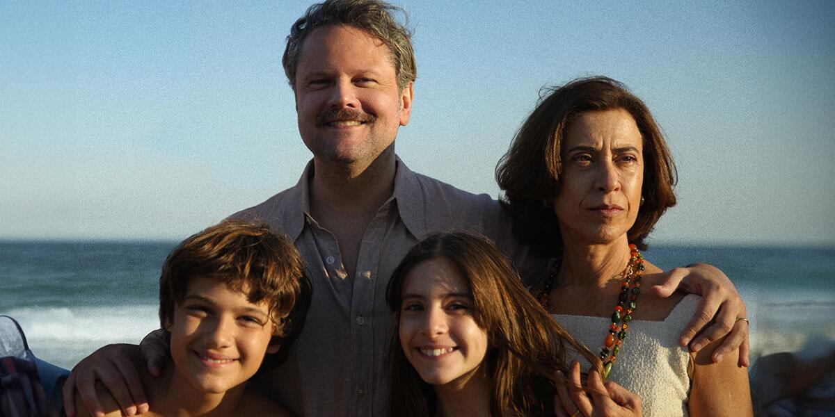 A family poses for a photograph on the beach. 