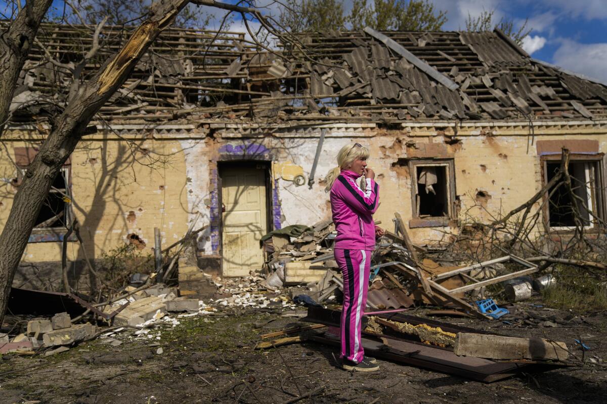 Iryna Martsyniuk, de 50 años, de pie junto a su casa, que sufrió graves daños tras un bombardeo ruso