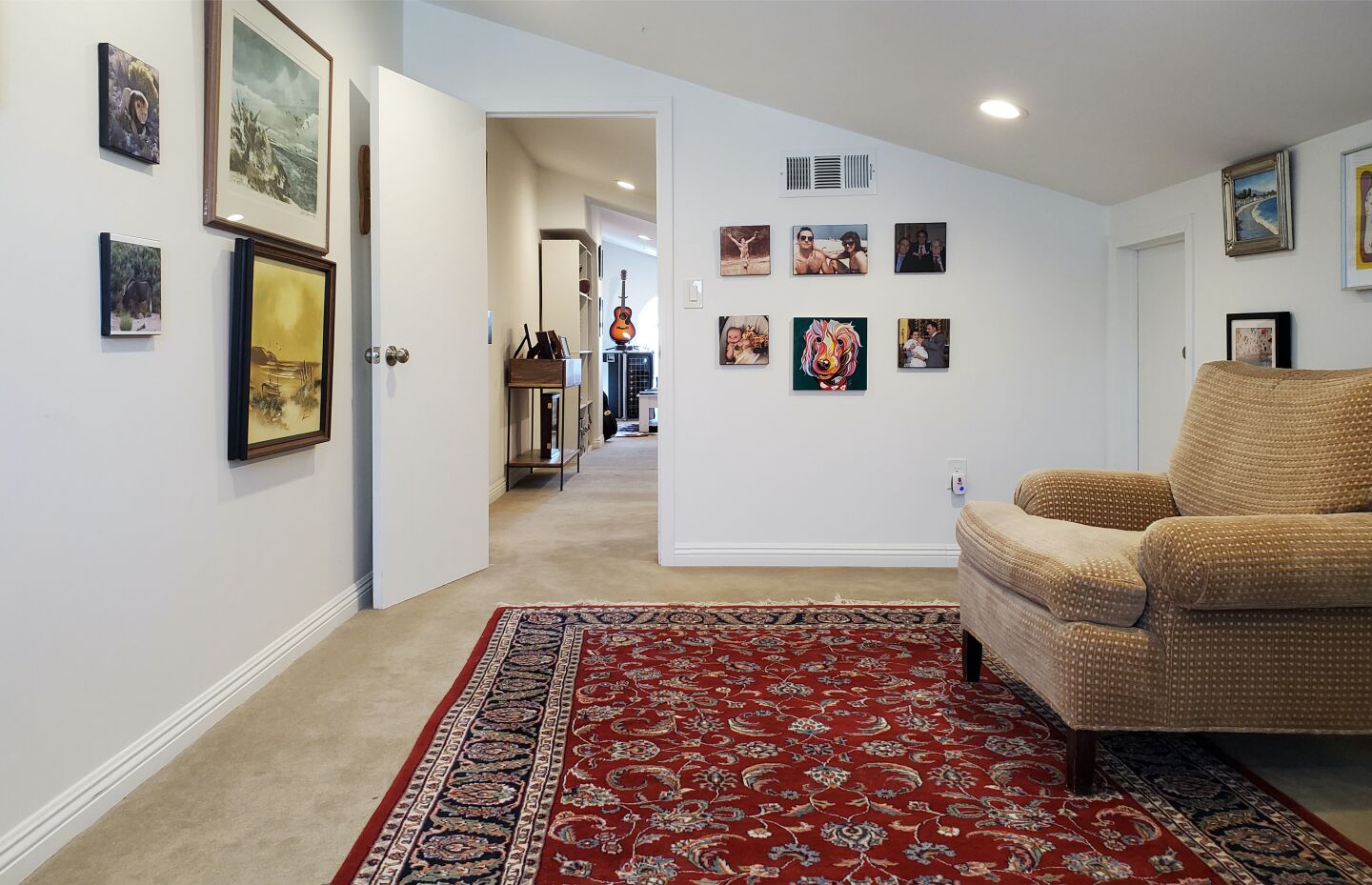 The attic has a furnished room with a rug.