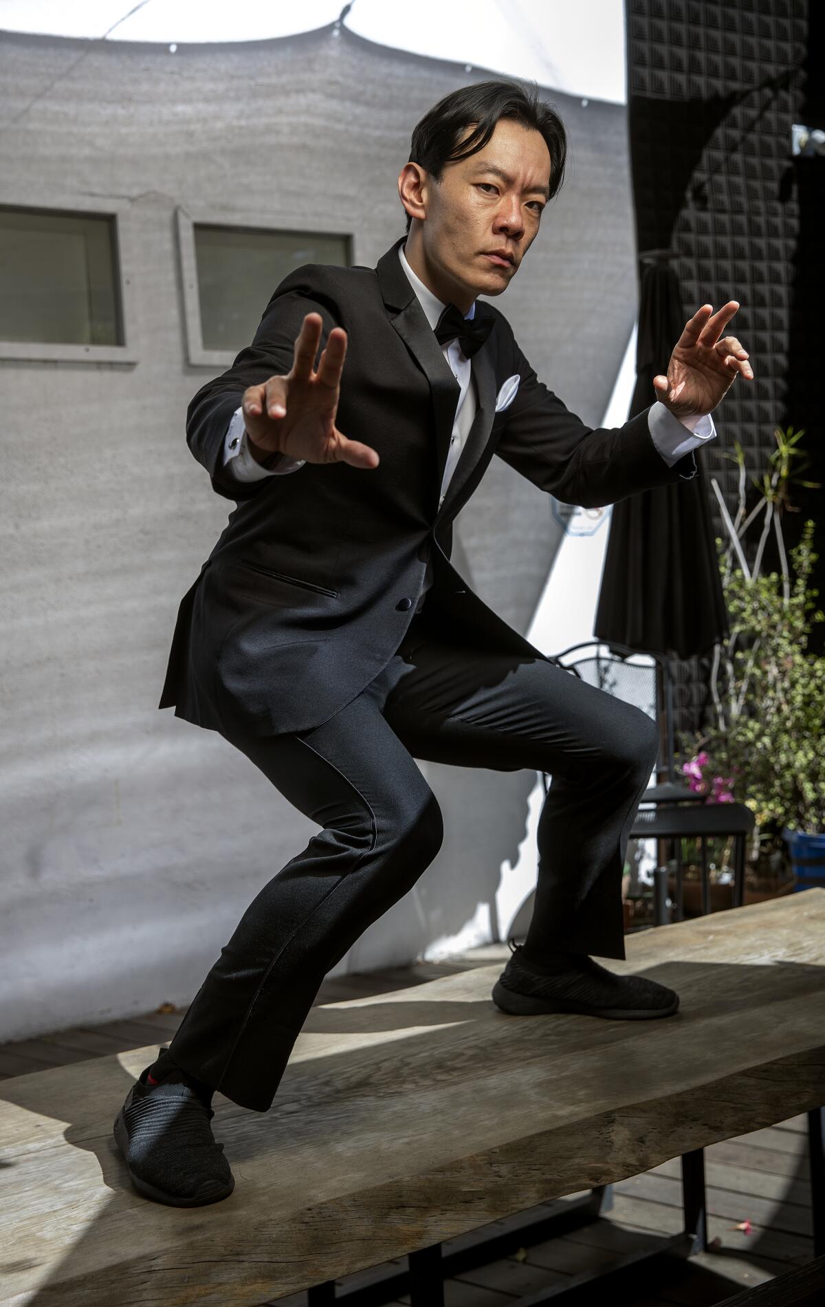 Man in black tux standing on a table