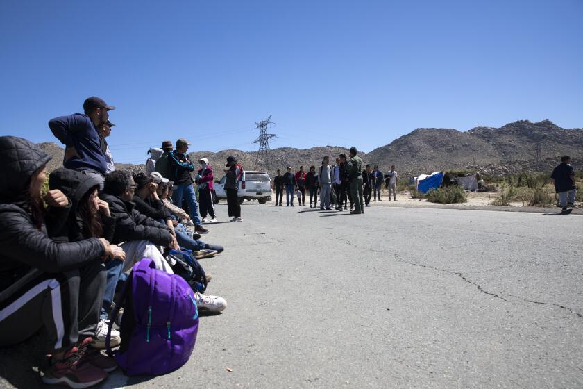 Jacumba Hot Springs, California - September 18: Hundreds of migrants wait to be processed by U.S. Border Patrol agents in a small desert town on Monday, Sept. 18, 2023 in Jacumba Hot Springs, California. About forty people, who have been in the area since Sunday, were taken to a border patrol station. The groups, many from China, Brazil, Colombia and Turkey, rely on volunteer groups for food. There were no bathrooms provided in one of the camps. (Ana Ramirez / The San Diego Union-Tribune)