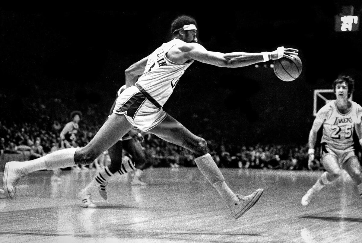 April 18, 1972: Wilt Chamberlain stretches to save the ball from going out of bounds during Game 5 of the NBA Western Conference playoffs with the Milwaukee Bucks.