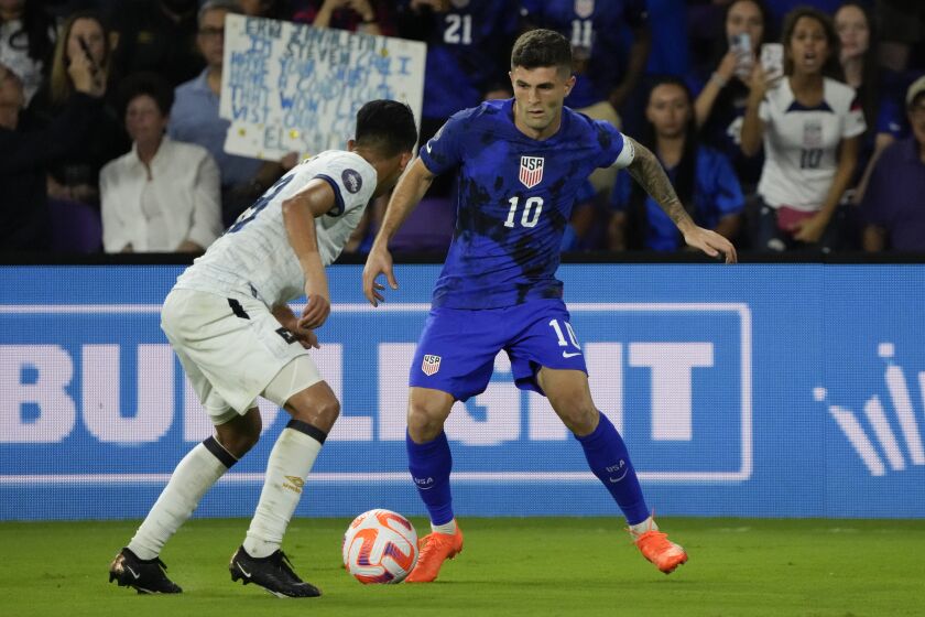 United States forward Christian Pulisic (10) looks for a way around El Salvador forward Kevin Reyes, left, during the second half of a CONCACAF Nations League soccer match Monday, March 27, 2023, in Orlando, Fla. (AP Photo/John Raoux)