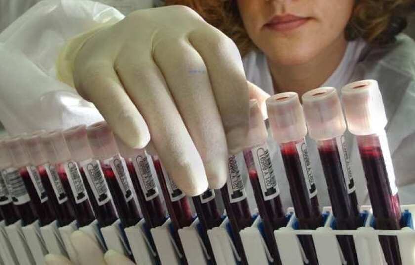 A researcher examines vials of blood