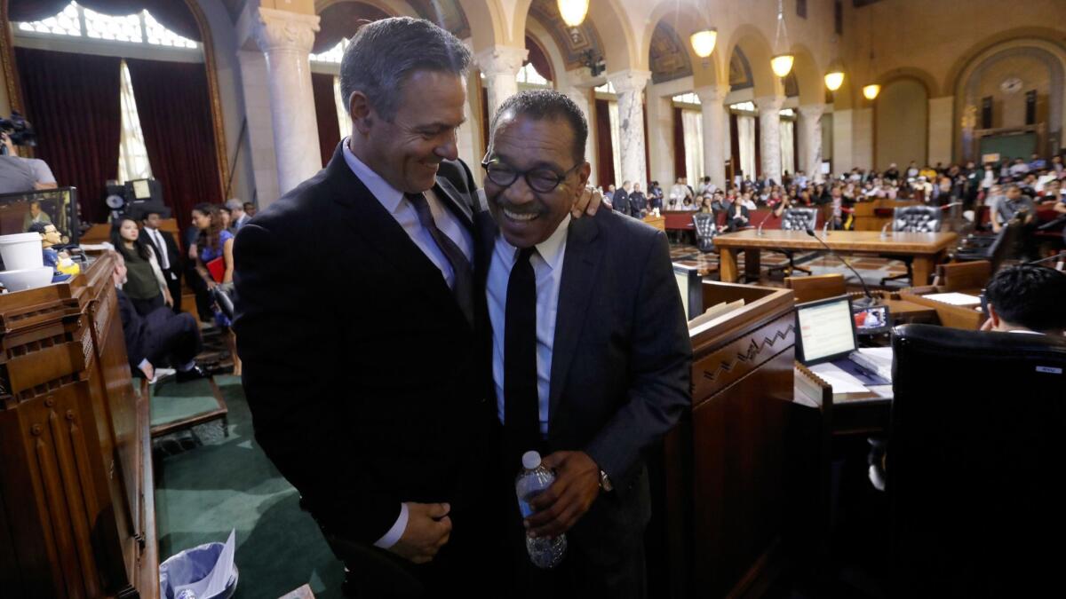 City Councilman Joe Buscaino, left, hugs Los Angeles City Council President Herb J. Wesson after Wesson spoke.