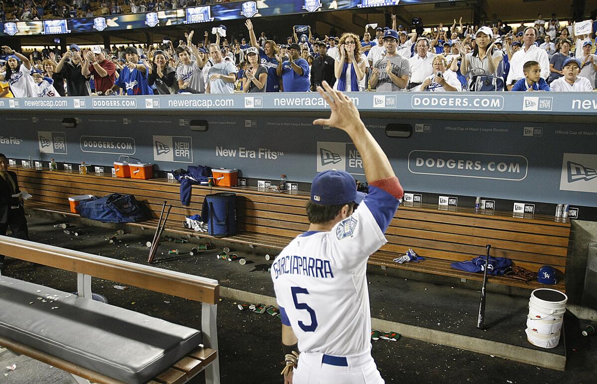 Dodgers shortstop Nomar Garciaparra waves goodbye to Dodgers fans as he leaves the field.