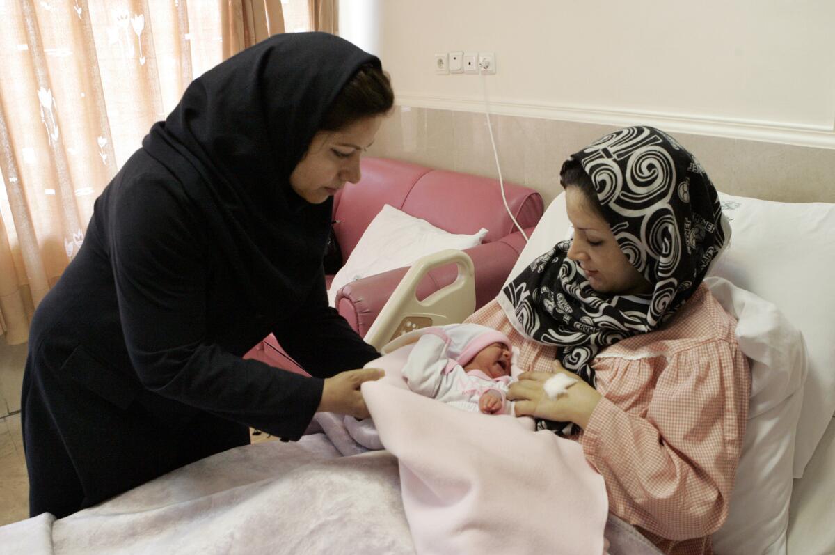 Hospital nurse with new mother and infant