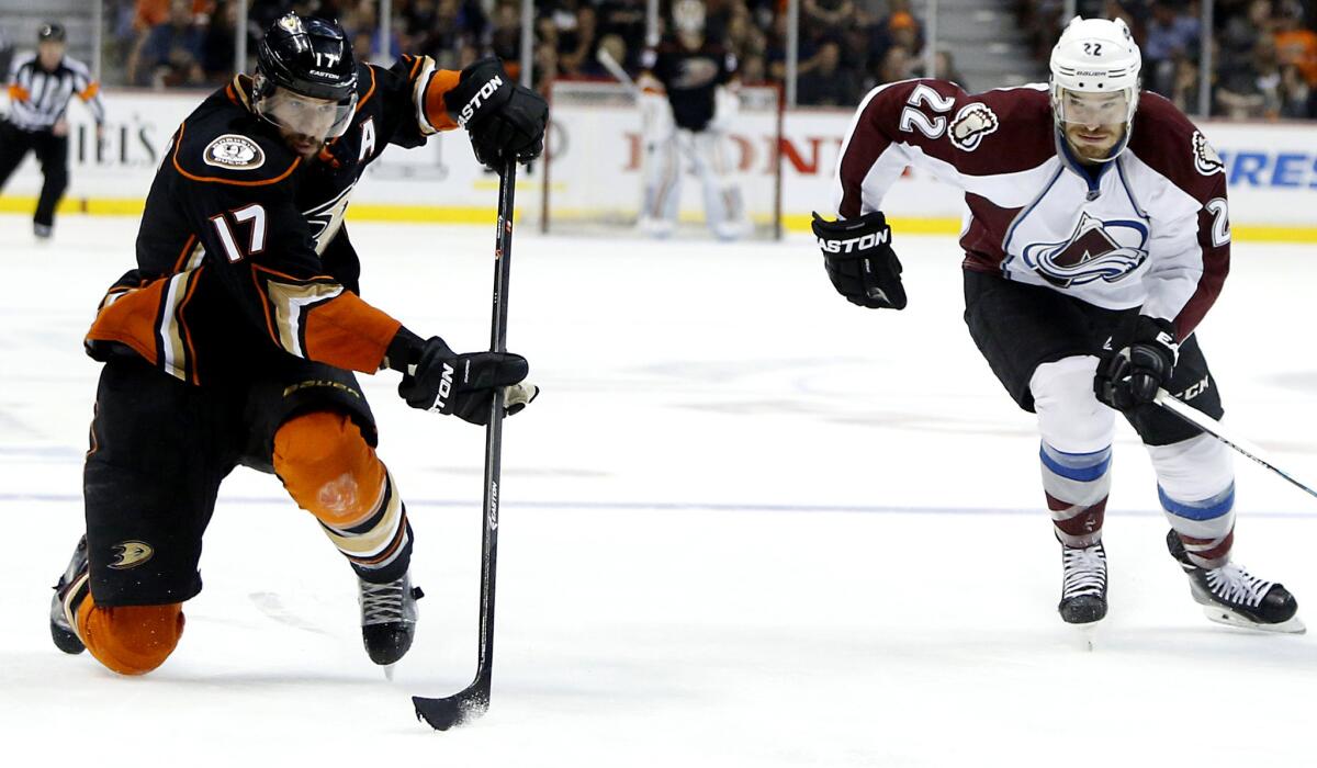 Ducks center Ryan Kesler passes the puck in front of Avalanche defenseman Zach Redmond in the second period Friday night at the Honda Center.