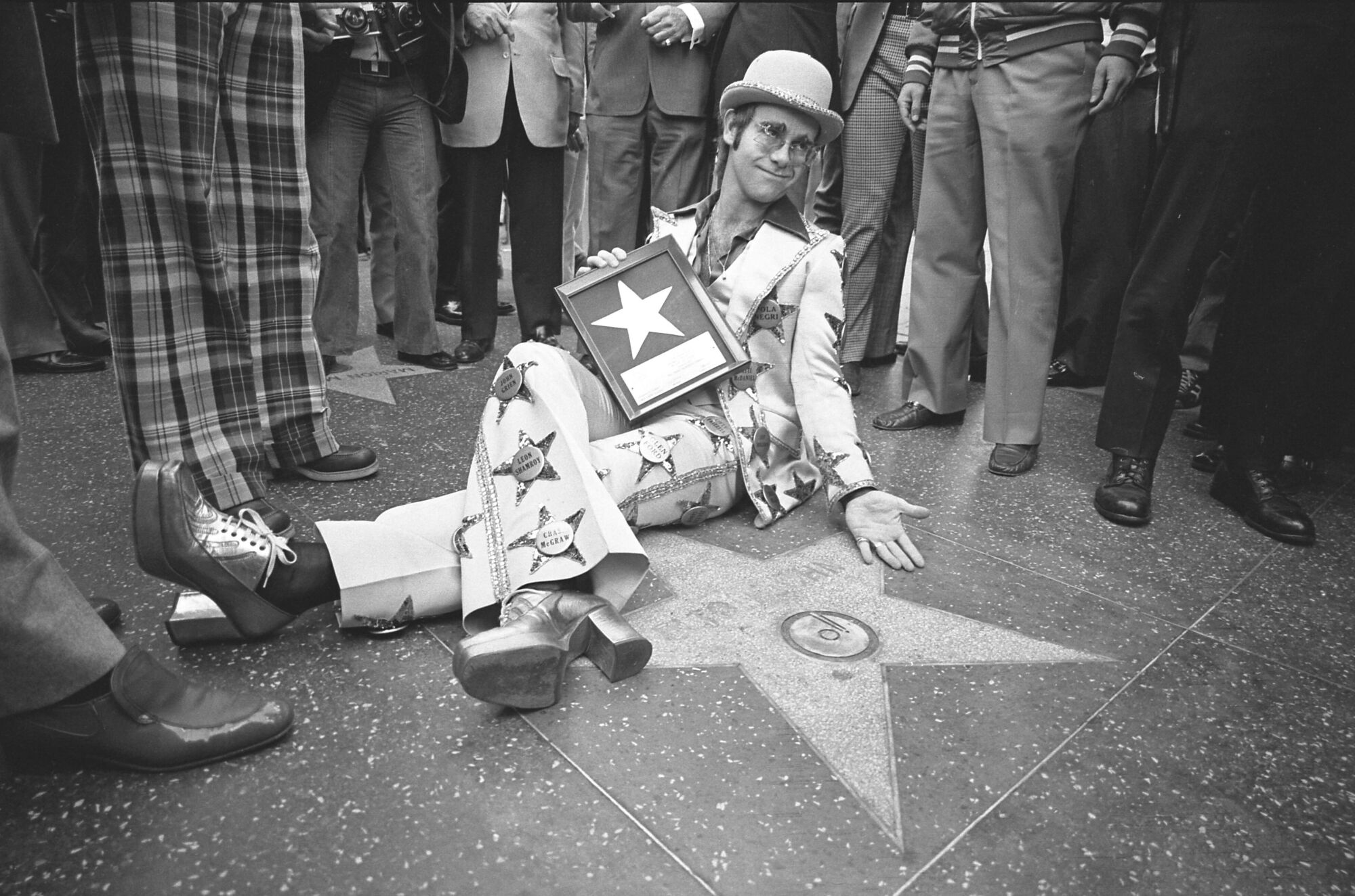Elton John is shown receiving his star on the Hollywood Walk of Fame in 1975.