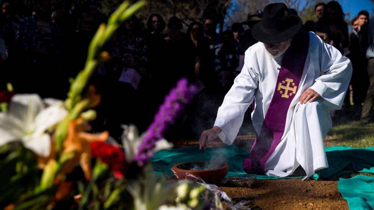 Deacon Ed Littleton kneels down to pay his respects during an interfaith service for the burial of unclaimed dead at L.A. County Cemetery.