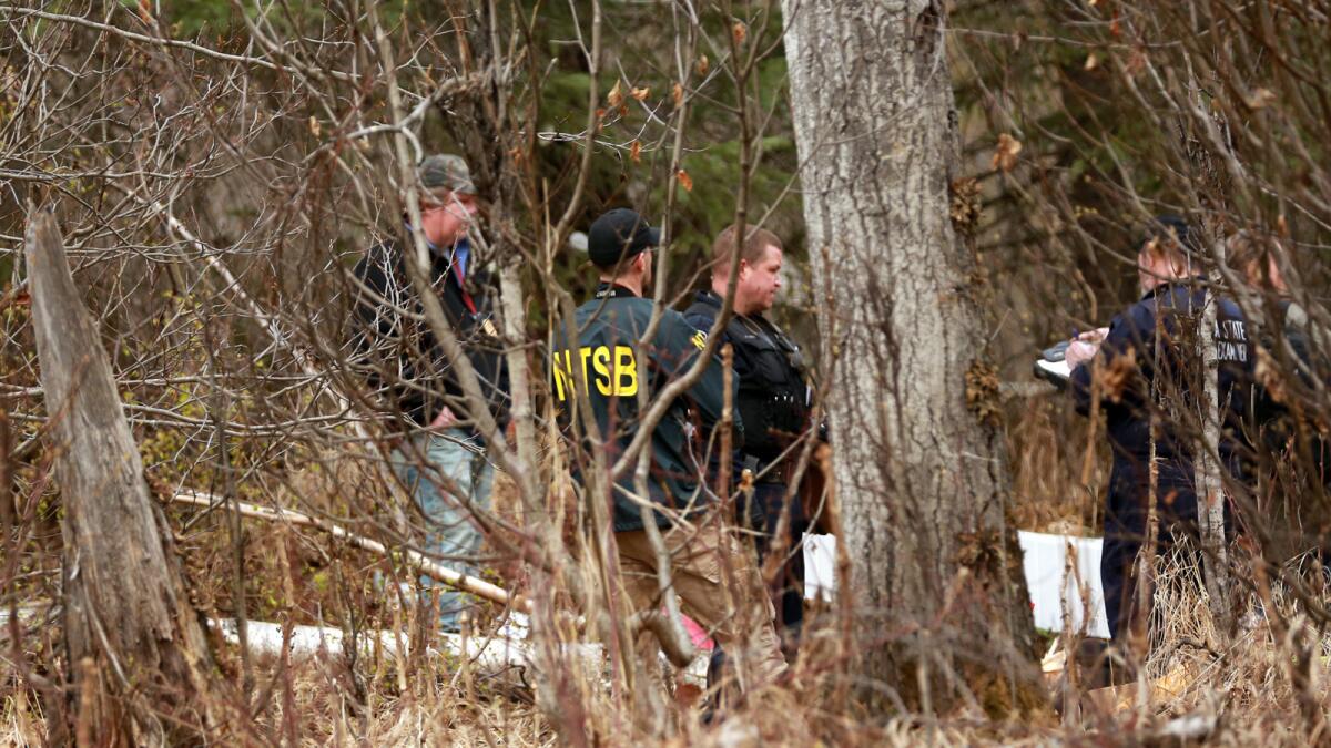 Investigators examine the scene of a fatal airplane crash on April 20 outside Anchorage.