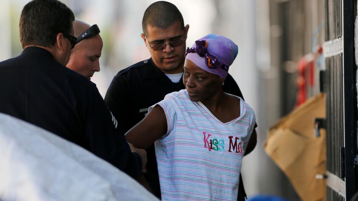 Officers make an arrest during a cleanup on skid row in April. Police treatment of street dwellers can veer between laissez-faire tolerance and coercive paternalism.