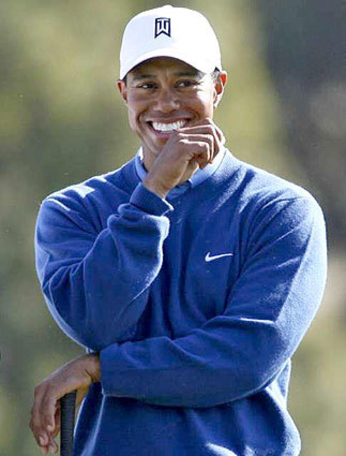 Tiger Woods, who grew up in Cypress and honed his game on Southland courses, smiles before hitting his drive on the 18th hole of the South Course at Torrey Pines during the third round of the Buick Invitational golf tournament in San Diego on Jan. 27.