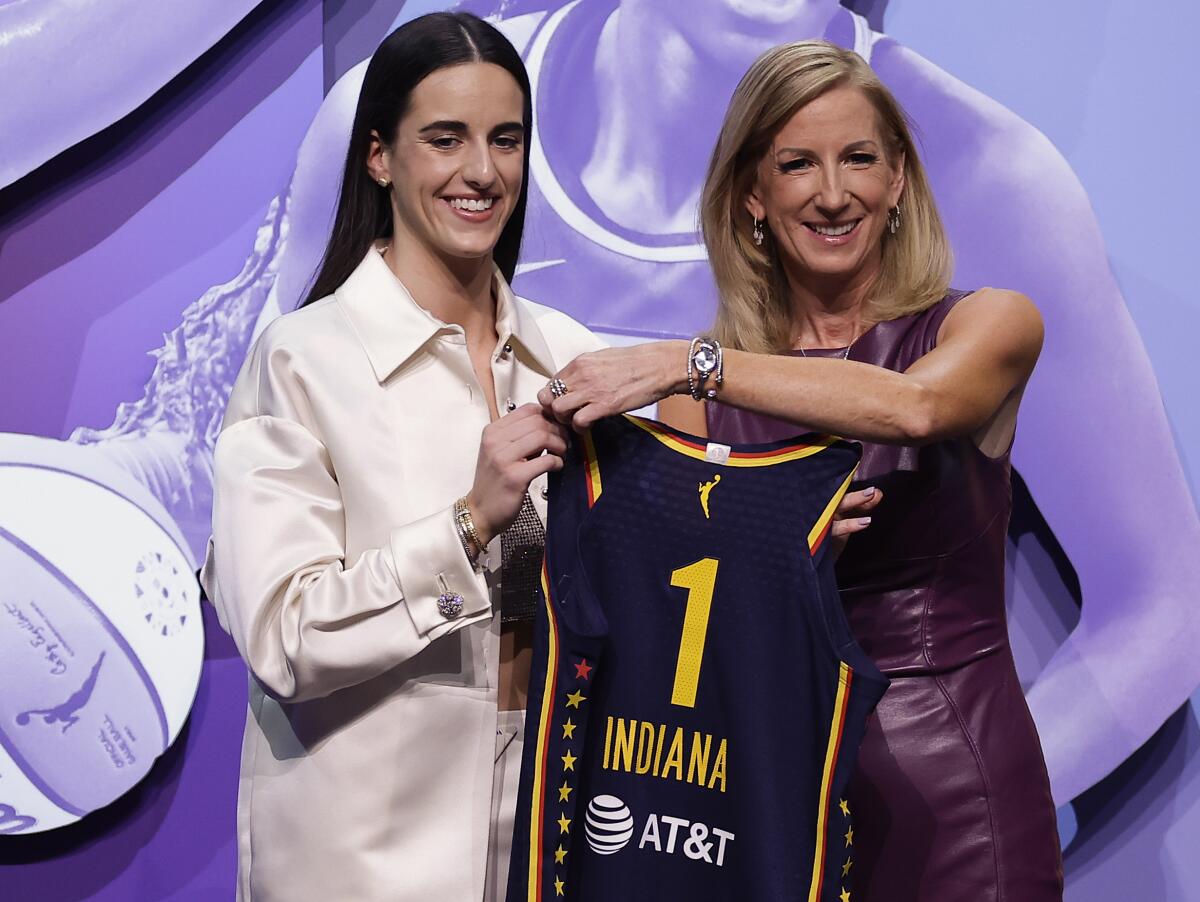 Caitlyn Clark and WNBA commissioner Cathy Engelbert hold up a No. 1 Indiana Fever jersey at the WNBA draft.