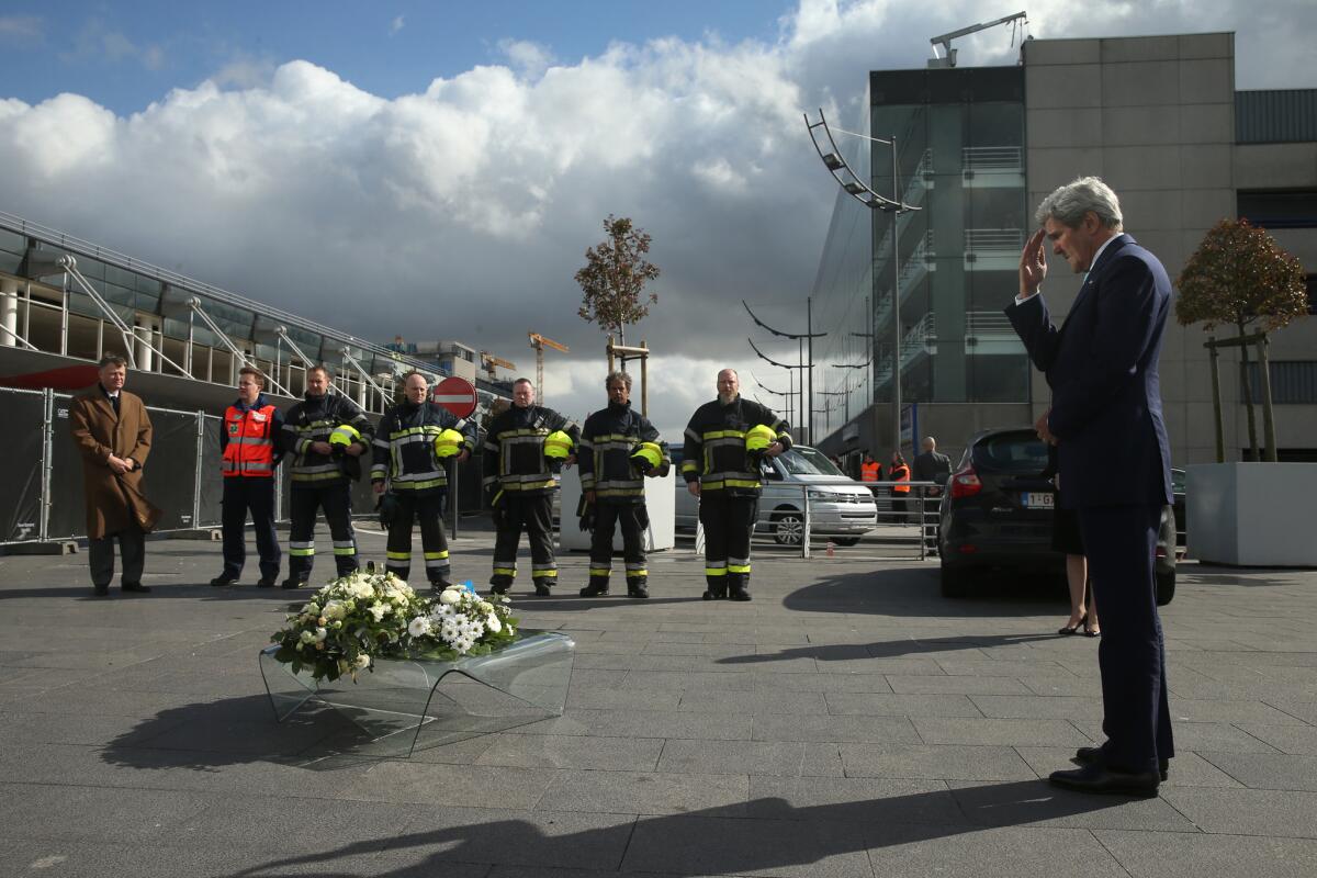 Secretary of State John F. Kerry salutes after laying a wreath at Brussels Airport in memory of victims of Tuesday's bombings.