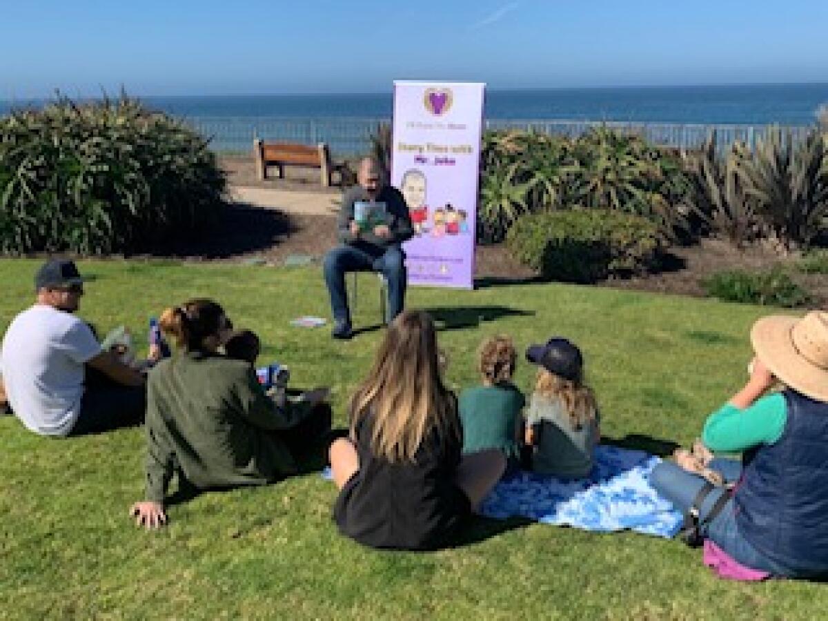 John Masiulionis reads a children’s book to youths