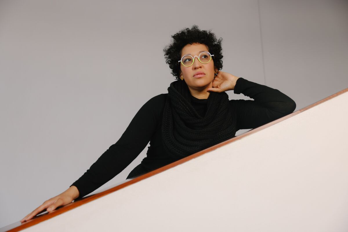 A woman poses on a staircase.