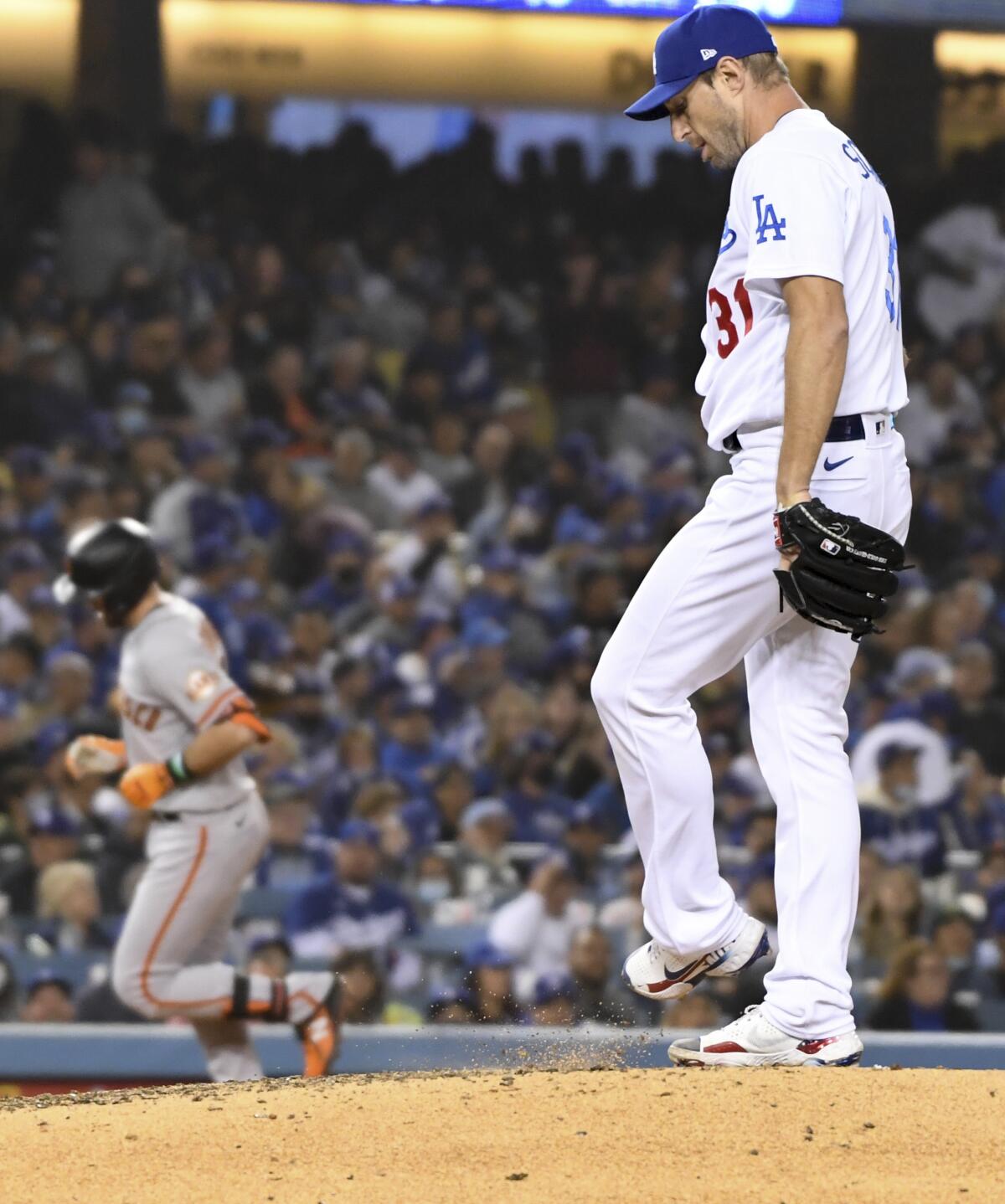 Max Scherzer kicks dirt off the mound at Dodger Stadium as Evan Longoria rounds the bases.