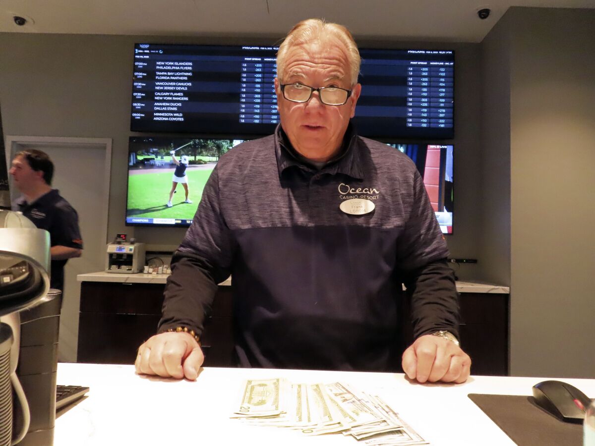 Frank Caltagirone, a sports book employee at the Ocean Casino Resort in Atlantic City, N.J., counts money from his drawer Monday, Feb. 6, 2023. On Feb. 7, 2023, the gambling industry's national trade group, the American Gaming Association, predicted that over 50 million American adults will bet a total of $16 billion on this year's Super Bowl, including legal bets with sports books, illegal ones with bookies, and casual bets among friends or relatives. (AP Photo/Wayne Parry)