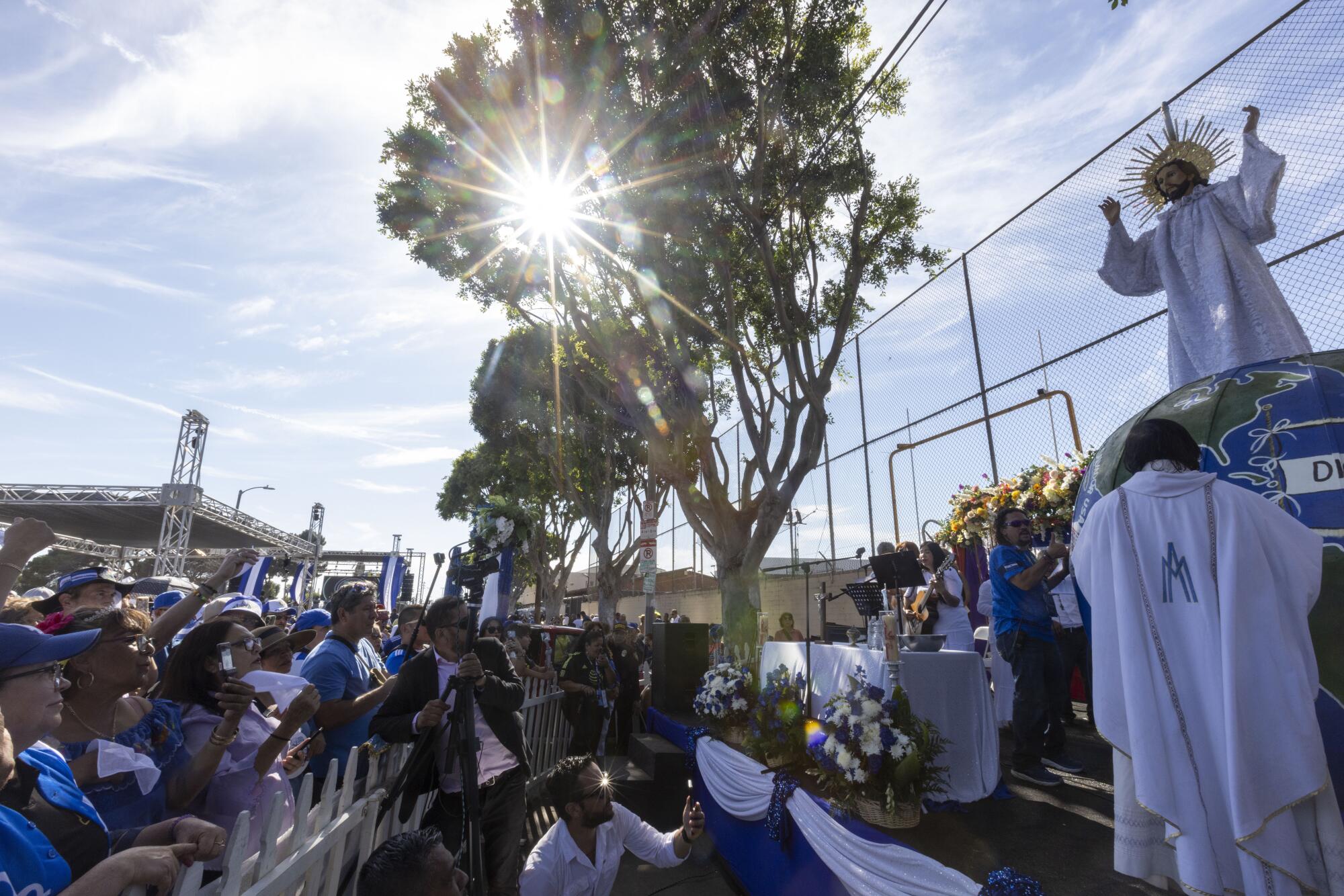 La figura de Jesucristo aparece vestida de blanco mientras el sacerdote Tomás López realiza una c