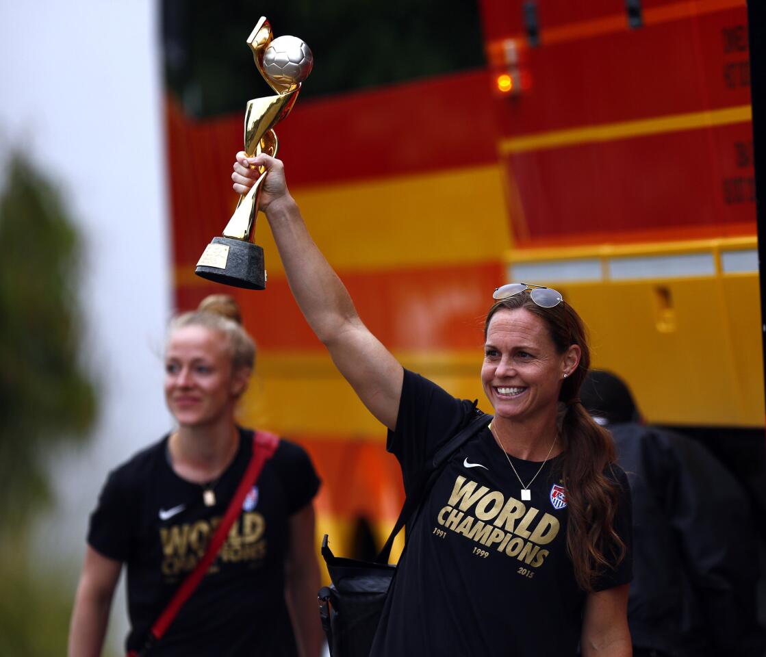 Defender Christie Rampone shows off the trophy after the U.S. women's soccer team arrives at the Los Angeles International Airport on Monday.