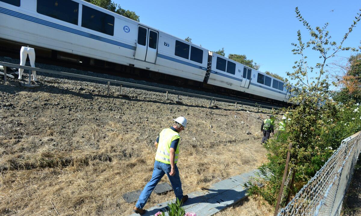 An investigator walks along tracks during a reenactment of Saturday's accident that killed two BART workers.
