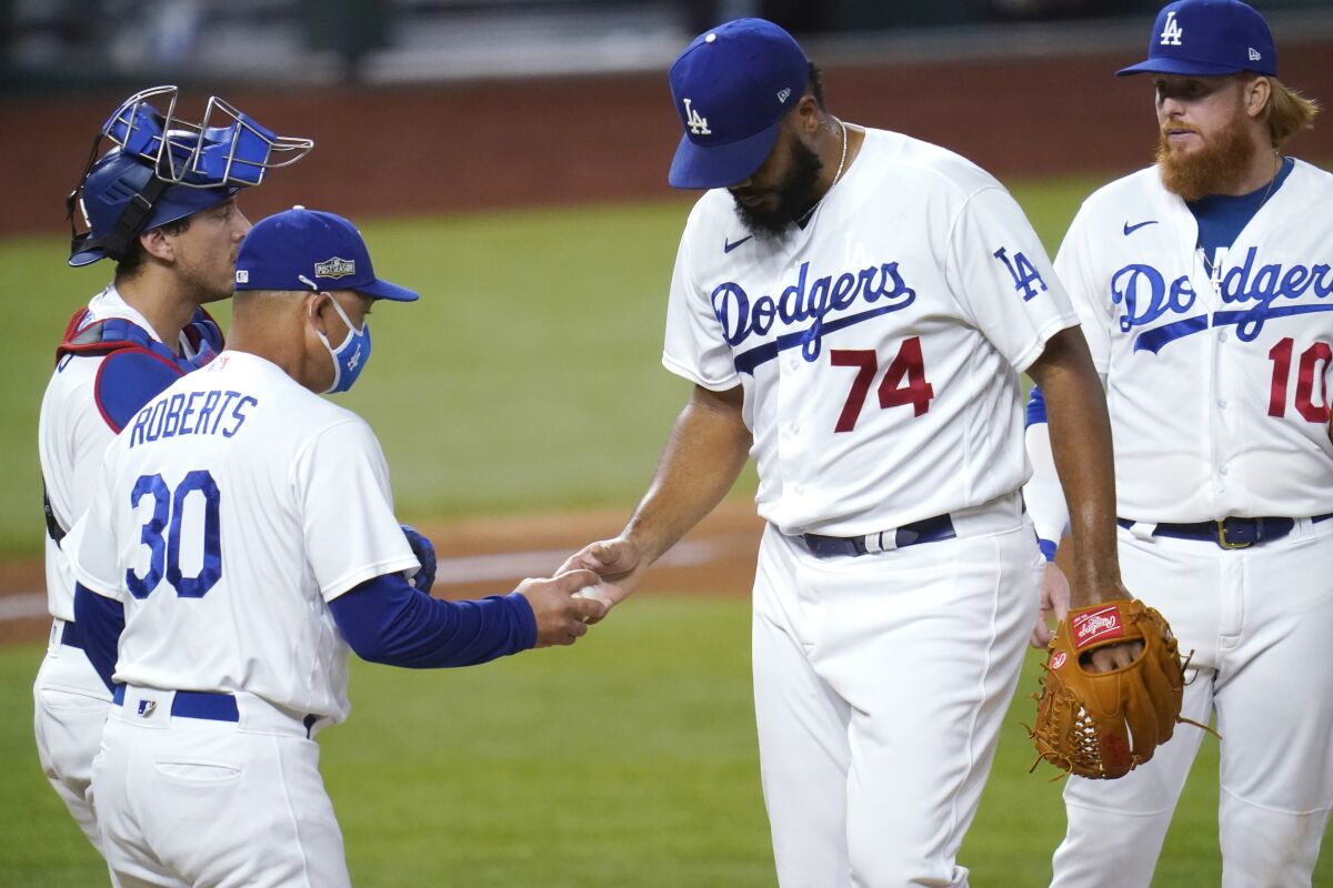 Dodgers manager Dave Roberts, left, pulls pitcher Kenley Jansen during Game 2 of the NLDS.
