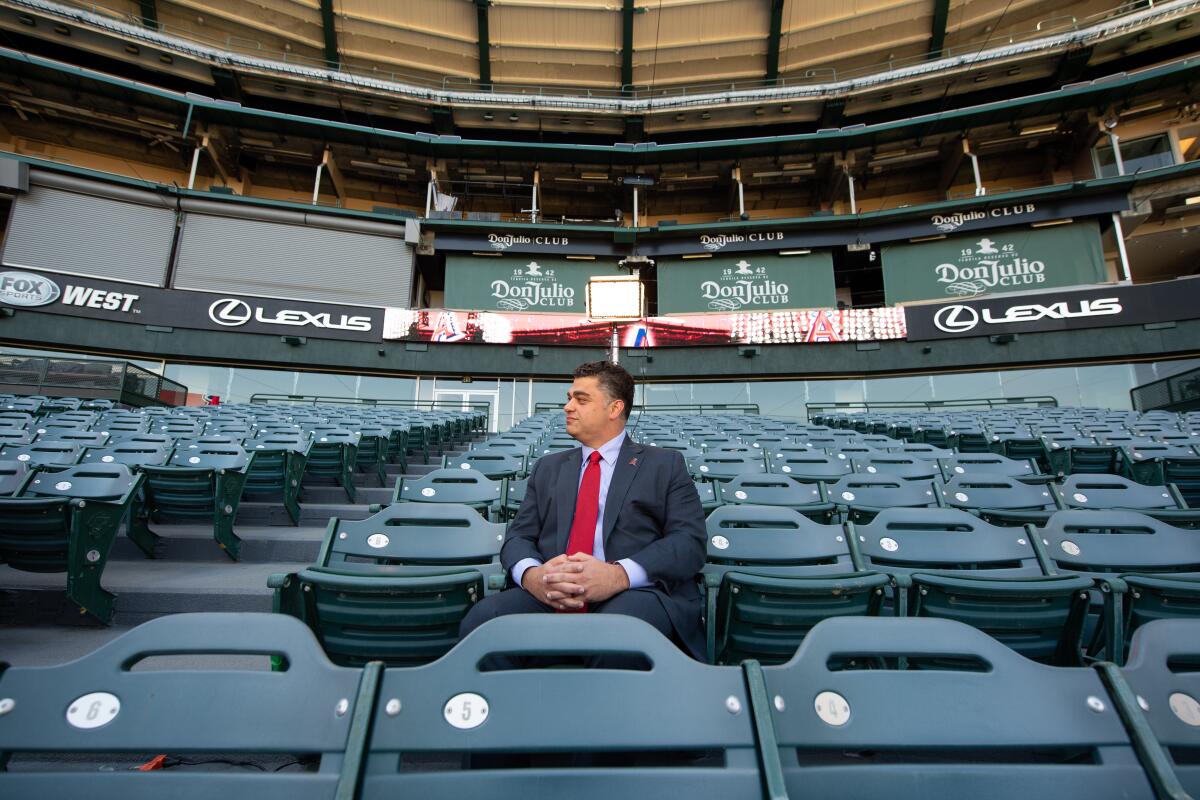 New Angels general manager Perry Minasian sits behind home plate at Angel Stadium.