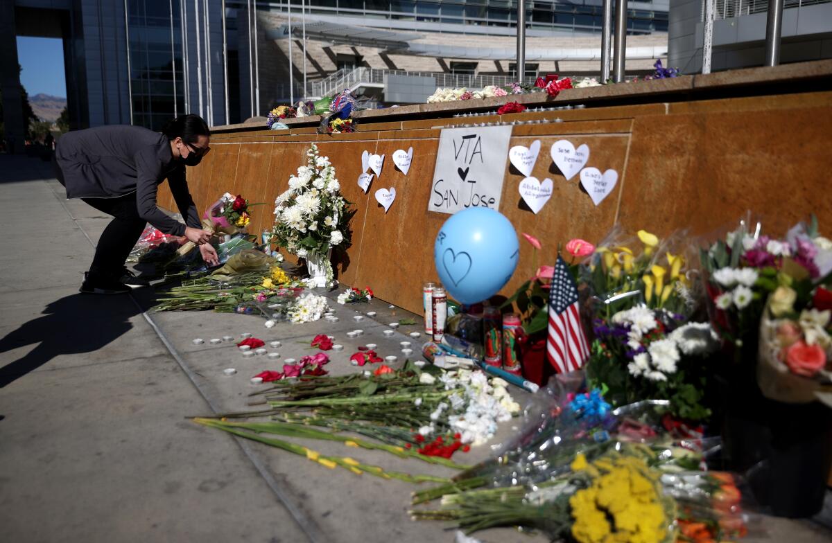 A mourner leaves flowers at a makeshift memorial in San Jose for the nine victims of a May 26 mass shooting.  