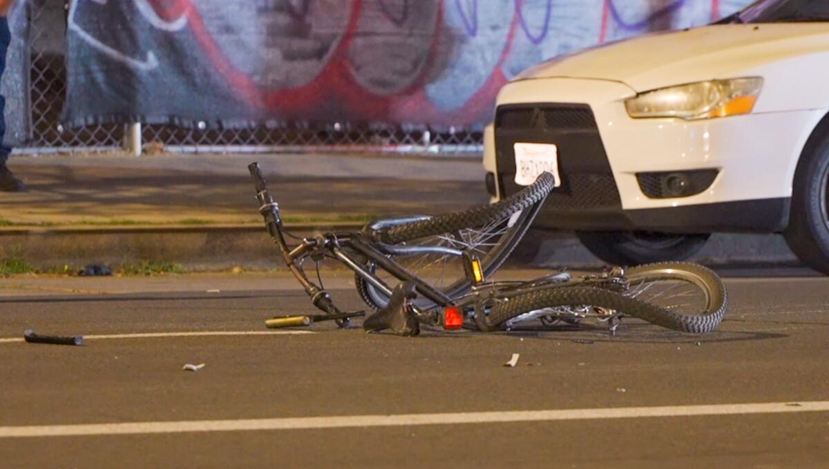 A mangled bicycle in the street surrounded by debris. 