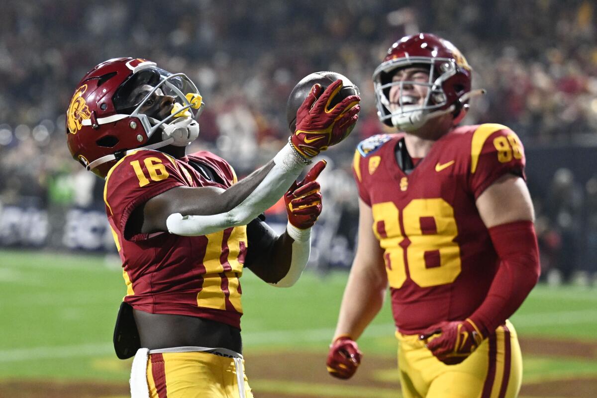 USC wide receiver Tahj Washington, left, celebrates a touchdown with tight end Kade Eldridge during the Holiday Bowl.