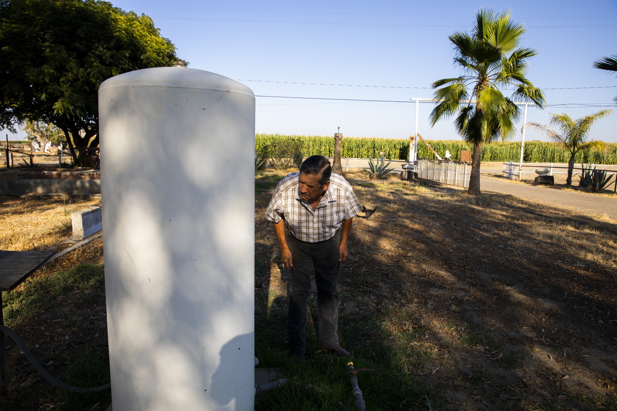 Jesús Benítez looks at his dropping water pressure at his home near Visalia.