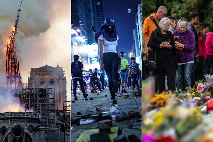 From left; The steeple of the landmark Notre-Dame Cathedral collapses as the cathedral is engulfed in flames in central Paris on April 15, 2019; Protester spread out bricks pulled from the sidewalk as obstacles on the road on Nathan Road in the Mong Kok district of Hong Kong, on Oct. 20, 2019; People pause next to flowers and tributes on March 17, 2019 in Christchurch, New Zealand, following a mass shooting at Al Noor mosque. (Geoffrey van der Hasselt/AFP/Getty Images; Marcus Yam/Los Angeles Times; Carl Court/Getty Images)