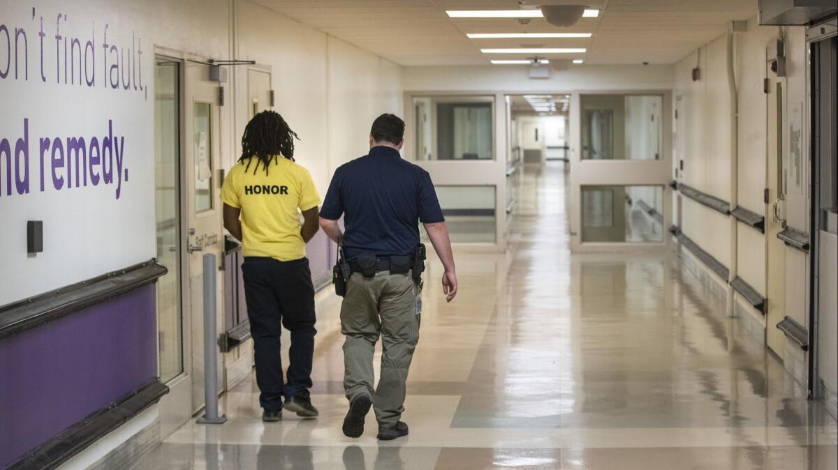 A staff member escorts a resident down a hallway at the Sacramento County Youth Detention Facility.