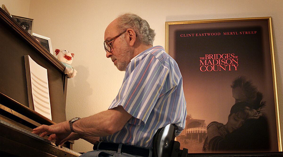 Lennie Niehaus at his piano with "The Bridges of Madison County" poster on the wall at his home in Thousand Oaks in 2000.