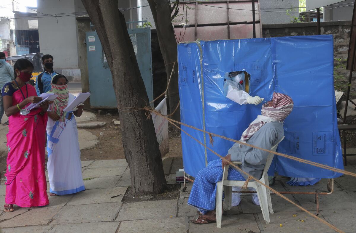 Health worker takes nasal swab in Hyderabad, India